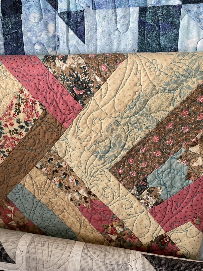 Diagonal strip quilt with pink rose and tan floral fabrics