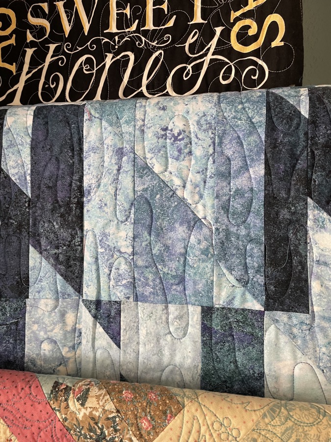 Blue batik strip quilt with abstract quilting pattern
