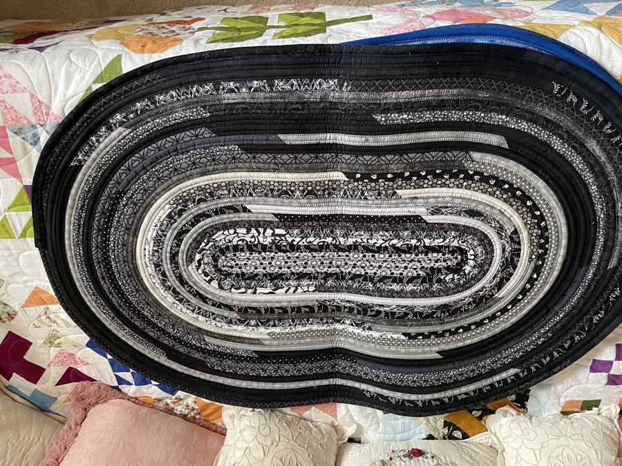 Handmade fabric rope rug in black white and gray oval shape